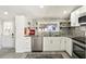 Well-lit kitchen offers stainless steel dishwasher, modern backsplash, and granite countertop at 1205 Wisconsin Ave, St Cloud, FL 34769