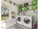 Practical laundry room featuring a side-by-side washer and dryer, shelving, and a bright window at 1205 Wisconsin Ave, St Cloud, FL 34769