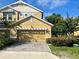 Charming two-story home with tan siding, a two-car garage, and a beautifully landscaped front yard at 14320 Desert Haven St # 3906, Windermere, FL 34786