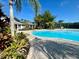 Community pool area with blue water, palm trees, and a clubhouse in the background on a sunny day at 14320 Desert Haven St # 3906, Windermere, FL 34786