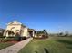 Community clubhouse with a brick walkway, manicured landscaping, and a view of the lake at 1509 Portofino Meadows Blvd, Orlando, FL 32824