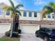 Inviting townhome featuring brick accents, attached garage, manicured lawn, and tropical palm trees at 1509 Portofino Meadows Blvd, Orlando, FL 32824
