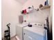 Bright laundry room featuring a white washer and dryer, wire shelving, and ample storage space at 1509 Portofino Meadows Blvd, Orlando, FL 32824