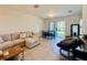 Inviting living area featuring tiled floors, plush seating, and sliding glass doors to outdoor at 1509 Portofino Meadows Blvd, Orlando, FL 32824