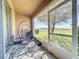 Relaxing screened balcony features a hanging chair, a table, and serene outdoor views at 1510 Chelsea Dr, Davenport, FL 33897