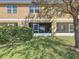 Exterior view of a screened lanai with views of a lush green lawn, shrubs, and a large tree at 1510 Chelsea Dr, Davenport, FL 33897
