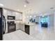 Bright, open-concept kitchen with stainless steel appliances and a view of the adjacent living area at 1510 Chelsea Dr, Davenport, FL 33897