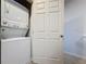 The laundry room with stacked washer and dryer, adjacent to a closed white door at 1510 Chelsea Dr, Davenport, FL 33897