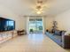 Bright living room featuring tile floors, ceiling fan, and sliding glass doors to the backyard at 1510 Chelsea Dr, Davenport, FL 33897