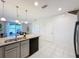 Living area with kitchen bar, tile flooring, white walls, and sliding glass door at 1510 Chelsea Dr, Davenport, FL 33897