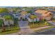 Aerial view of a single Gathering home with a well maintained lawn and brick driveway in a residential neighborhood at 153 Cambridge Ave, Davenport, FL 33896