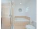 Bright bathroom showcasing a tiled shower, soaking tub, and unique round window at 153 Cambridge Ave, Davenport, FL 33896