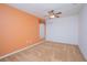 Bedroom with orange accent wall, neutral carpet, ceiling fan, and ample closet space at 153 Cambridge Ave, Davenport, FL 33896
