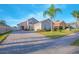 Well-maintained single-story home with a brick driveway, palm tree in the front yard, manicured landscaping, and neutral paint at 153 Cambridge Ave, Davenport, FL 33896