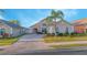 Well-maintained single-story home with a brick driveway and mature palm tree in the front yard, side yard, and neutral paint at 153 Cambridge Ave, Davenport, FL 33896