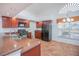 Kitchen featuring dark appliances, wooden cabinets, granite countertops, tile flooring, breakfast nook and a vaulted ceiling at 153 Cambridge Ave, Davenport, FL 33896