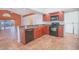 Open kitchen featuring dark appliances, wooden cabinets, granite countertops, tile flooring, and a breakfast bar at 153 Cambridge Ave, Davenport, FL 33896