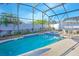 Fully screened pool and spa with landscaping and patio furniture at 153 Cambridge Ave, Davenport, FL 33896