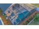 Aerial shot of the screened-in pool featuring a hot tub, seating, and foliage around the area at 153 Cambridge Ave, Davenport, FL 33896