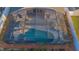 A backyard screened-in pool is shown with seating and attractive foliage surrounding the area at 153 Cambridge Ave, Davenport, FL 33896