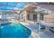 This stunning screened-in pool area features an umbrella-shaded dining set, providing the perfect setting for relaxation and dining at 153 Cambridge Ave, Davenport, FL 33896