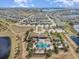 Aerial view showing community clubhouse, pools, landscaping, and neighborhood with lakes in the background at 16694 Olive Hill Dr, Winter Garden, FL 34787