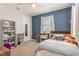 Cozy bedroom featuring a plush bed, bookshelf with vines, and a calming blue accent wall at 16694 Olive Hill Dr, Winter Garden, FL 34787