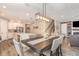 Open-concept dining area with stylish lighting adjacent to the kitchen and living room at 16694 Olive Hill Dr, Winter Garden, FL 34787