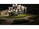 Nighttime exterior elevation view of a two-story home with manicured lawn and landscaping at 16694 Olive Hill Dr, Winter Garden, FL 34787