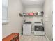 Functional laundry room equipped with modern washer and dryer units plus shelving at 16694 Olive Hill Dr, Winter Garden, FL 34787