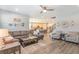 Open-concept living room with hardwood floors flows to the kitchen and has a ceiling fan at 16694 Olive Hill Dr, Winter Garden, FL 34787