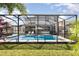 Backyard pool with screened enclosure, patio seating, landscaping, and view of two-story home at 16694 Olive Hill Dr, Winter Garden, FL 34787