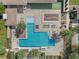 An aerial view of a community pool area with brick pavers, lounge chairs, and decorative palm trees at 16694 Olive Hill Dr, Winter Garden, FL 34787