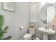 Chic powder room featuring a pedestal sink, decorative mirror, and subtle decor at 16694 Olive Hill Dr, Winter Garden, FL 34787