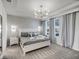 This bedroom boasts a modern chandelier, geometric accent wall, and plush gray carpeting at 1800 Tropical Palms Cir, Kissimmee, FL 34747