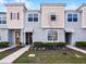 Charming townhouse featuring a modern design with complementary colored stucco and siding, landscaped front yard, and inviting entries at 1800 Tropical Palms Cir, Kissimmee, FL 34747