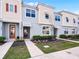 Charming townhouse featuring a modern design with complementary colored stucco and siding, landscaped front yard, and inviting entries at 1800 Tropical Palms Cir, Kissimmee, FL 34747