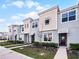 Charming townhouses featuring a modern design with complementary colored stucco and siding, landscaped front yard, and inviting entries at 1800 Tropical Palms Cir, Kissimmee, FL 34747