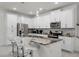Bright kitchen featuring white cabinetry, stainless steel appliances, bar seating around an island with a marble countertop at 1800 Tropical Palms Cir, Kissimmee, FL 34747