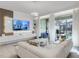 Bright and spacious living room featuring an open floorplan, modern lighting, white L-shaped sofa and a large, wall-mounted TV at 1800 Tropical Palms Cir, Kissimmee, FL 34747