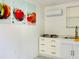 Bright kitchen featuring white cabinetry, stainless steel appliances, and fruit-themed wall art at 18304 Cedarhurst Rd, Orlando, FL 32820