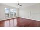 Spacious bedroom featuring hardwood floors, three large windows, and a ceiling fan at 2250 Windcrest Lake Cir, Orlando, FL 32824