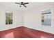 Bedroom featuring hardwood floors, ceiling fan, and two large windows at 2250 Windcrest Lake Cir, Orlando, FL 32824