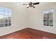 Bedroom featuring hardwood floors, ceiling fan, and two large windows at 2250 Windcrest Lake Cir, Orlando, FL 32824