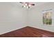 An empty bedroom features hardwood floors, a ceiling fan, and a sunlit window at 2250 Windcrest Lake Cir, Orlando, FL 32824