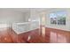 Bright hallway with hardwood floors, white railings, and large windows offering natural light at 2250 Windcrest Lake Cir, Orlando, FL 32824