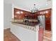 Charming kitchen features dark wood cabinets, stainless appliances, and breakfast bar seating at 2250 Windcrest Lake Cir, Orlando, FL 32824
