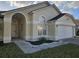 Attractive one-story home with an arched entryway and landscaped garden at 231 Old Mill Cir, Kissimmee, FL 34746