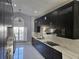 Modern kitchen featuring dark cabinetry, stainless steel appliances, and a bright window at 231 Old Mill Cir, Kissimmee, FL 34746