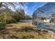 A large backyard with a pool, a screened enclosure, and a privacy fence at 248 Breezy Oaks Ct, Davenport, FL 33896